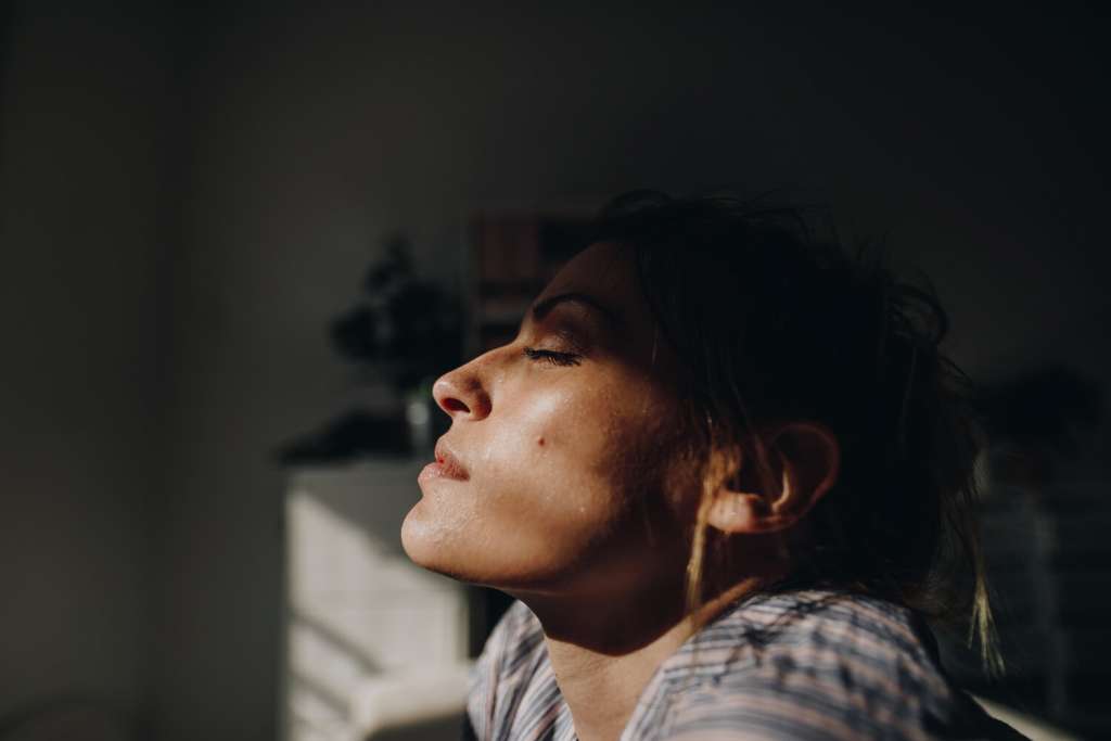 Mujer con los ojos cerrados en una habitación analizando sus tipos de intuición.