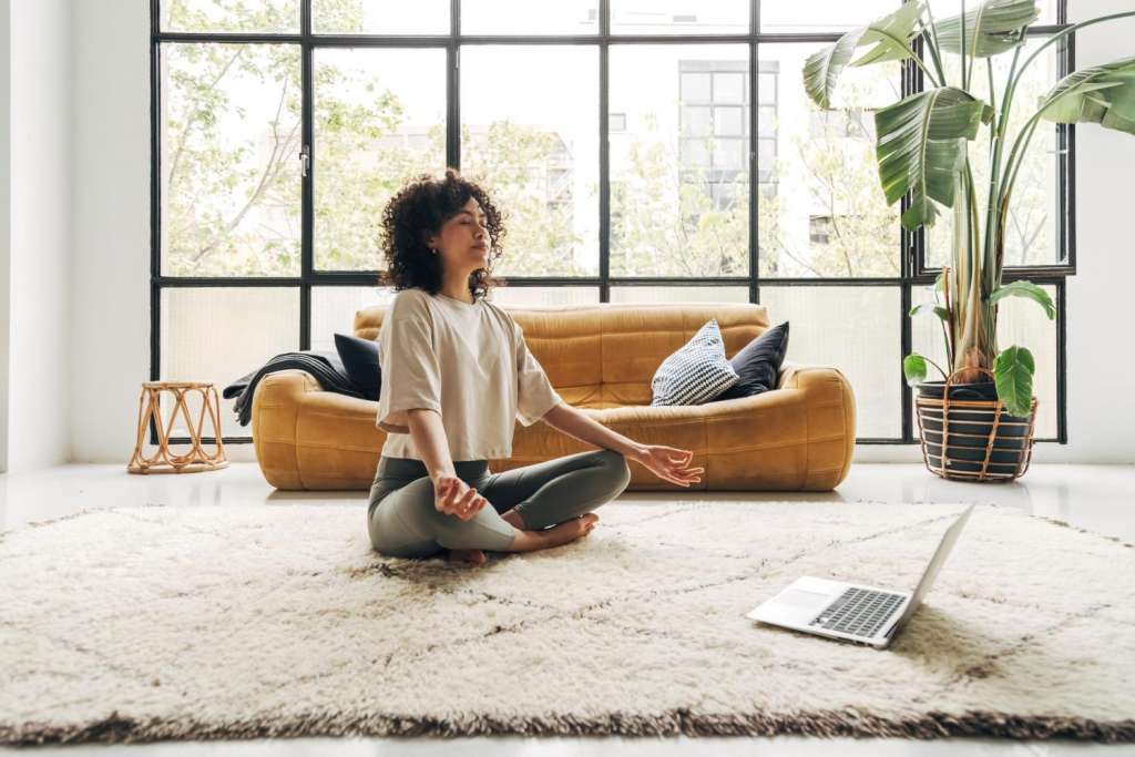 Mujer sentada en el suelo realizando la meditación de consciencia abierta